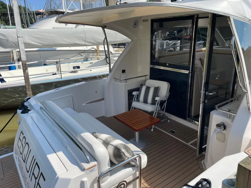 Slide: The Image of 2017 Riviera 3600 Sport Yacht with elegant outdoor seating and wooden table. - 14