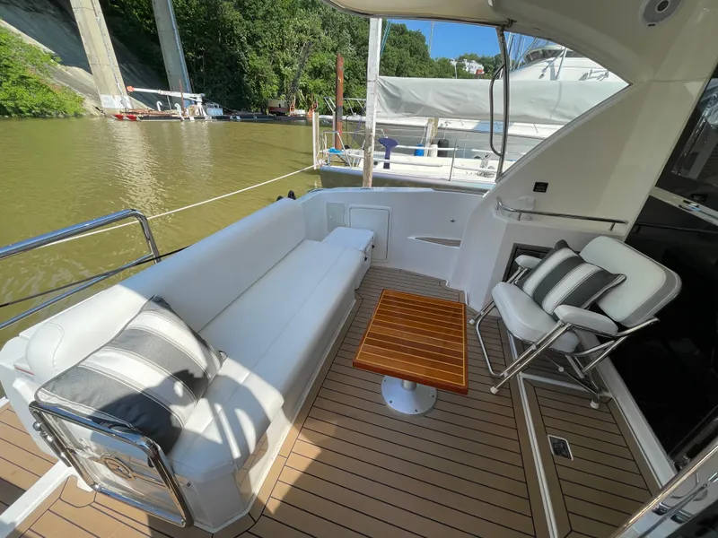 Slide: The Image of Luxurious 2017 Riviera 3600 Sport Yacht deck with elegant seating and wooden table. - 15