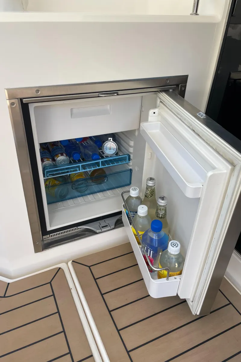 Slide: The Image of Open mini fridge on 2017 Riviera 3600 Sport Yacht, stocked with beverages. - 20