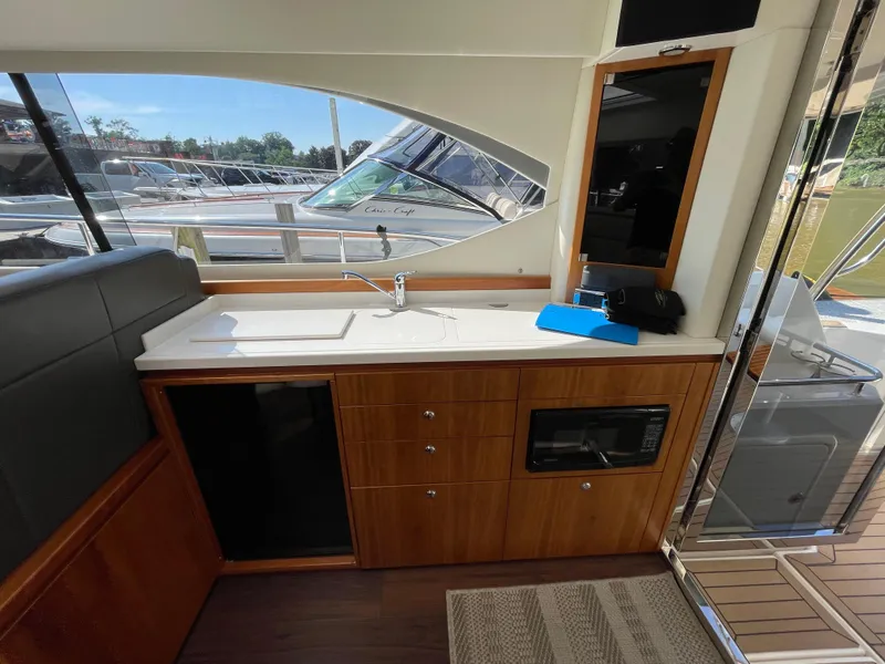 Slide: The Image of Interior of 2017 Riviera 3600 Sport Yacht with kitchenette and seating area. - 24