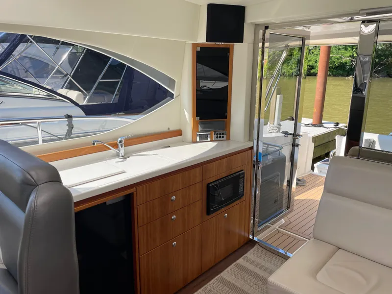 Slide: The Image of Interior of 2017 Riviera 3600 Sport Yacht with kitchenette and outdoor view. - 25