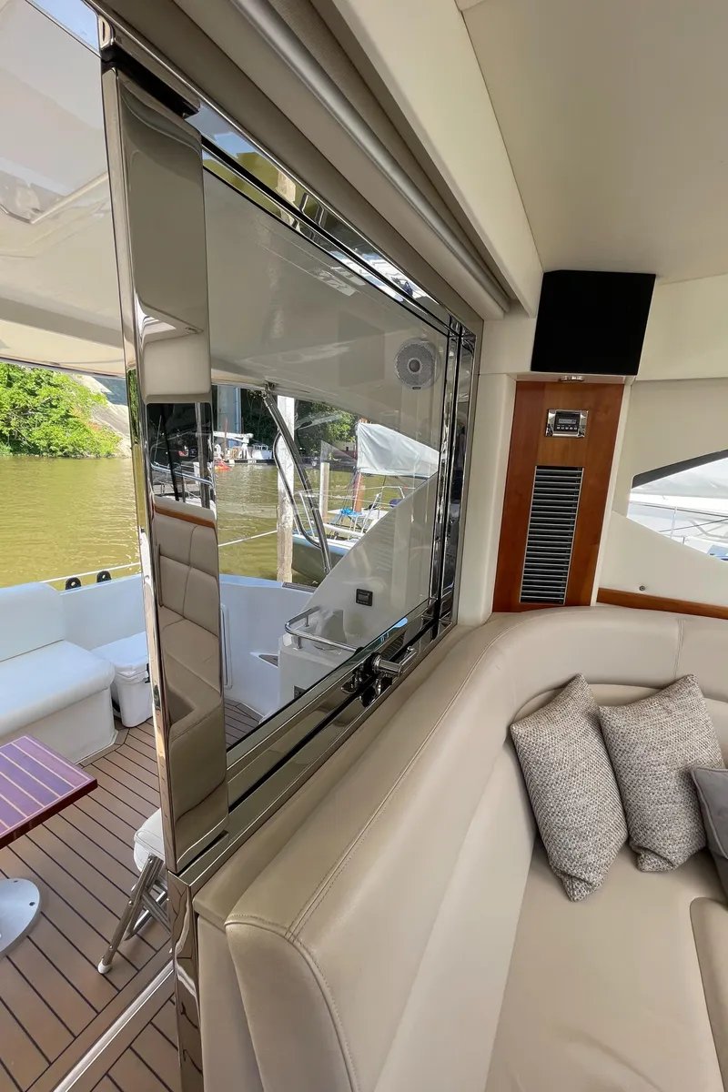Slide: The Image of Interior of 2017 Riviera 3600 Sport Yacht with plush seating and outdoor view. - 27