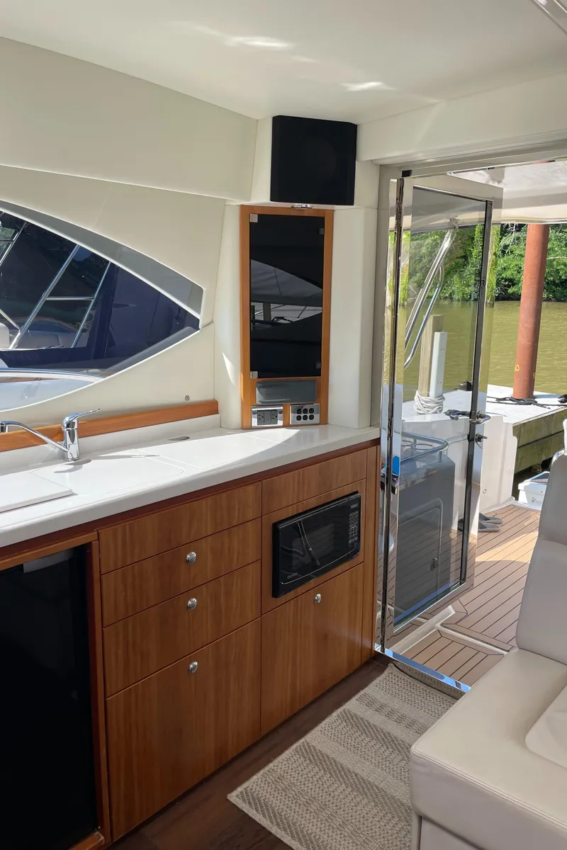 Slide: The Image of Interior of 2017 Riviera 3600 Sport Yacht with kitchenette and outdoor view. - 29