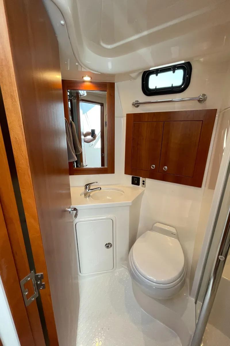 Slide: The Image of 2017 Riviera 3600 Sport Yacht bathroom with wooden cabinets and modern fixtures. - 44