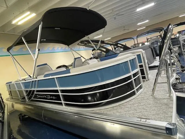 Slide: The Image of 2025 South Bay LE pontoon boat with canopy in showroom. - 2
