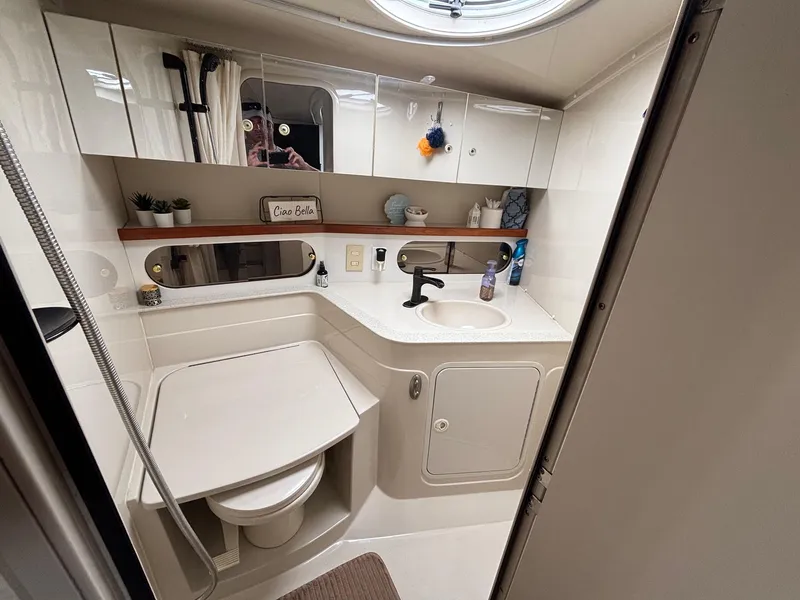 Slide: The Image of 1998 Cruisers Yachts 3575 Express bathroom with sink, mirror, and storage cabinets. - 10