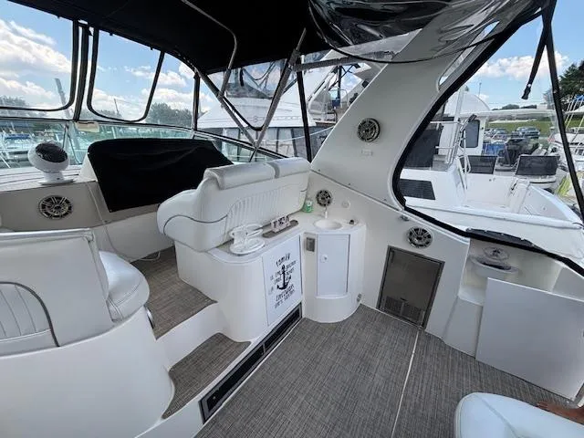 Slide: The Image of 1998 Cruisers Yachts 3575 Express interior with seating and helm, docked at marina. - 2
