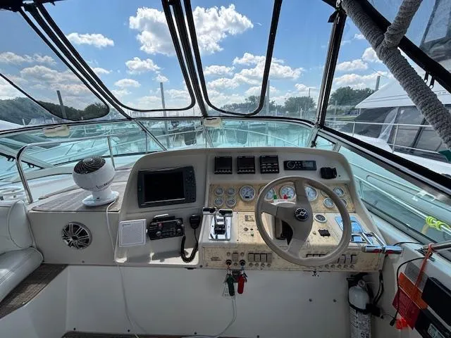 Slide: The Image of 1998 Cruisers Yachts 3575 Express helm with steering wheel, gauges, and navigation equipment. - 5