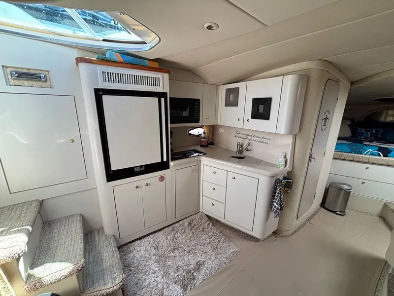Slide: The Image of 1998 Cruisers Yachts 3575 Express interior with kitchenette, bed, and stairs. - 6