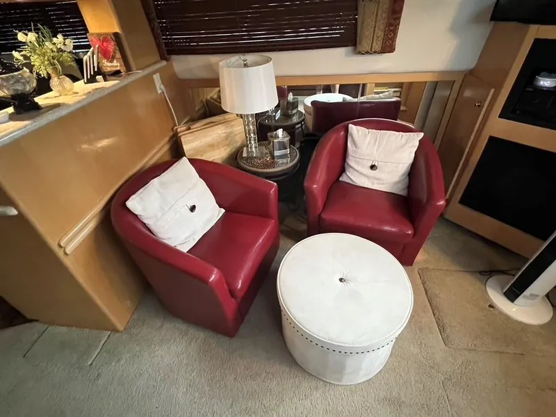 Slide: The Image of Cozy seating area in 1998 Carver 455 Aft Cabin Motoryacht with red chairs and white ottoman. - 12