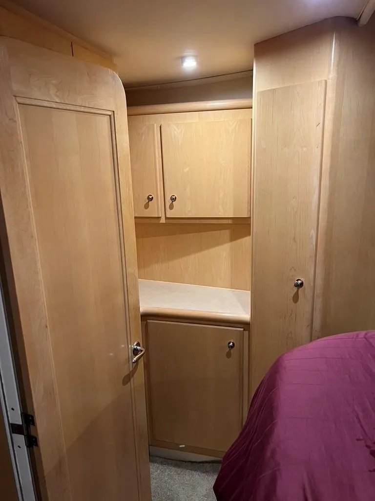 Slide: The Image of Interior of 1998 Carver 455 Aft Cabin Motoryacht with wooden cabinetry and purple bedding. - 20