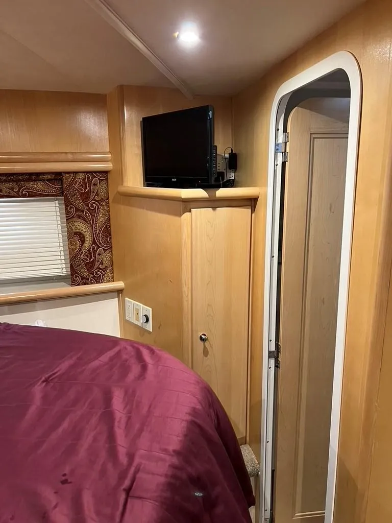Slide: The Image of Interior of 1998 Carver 455 Aft Cabin Motoryacht with TV and maroon bedding. - 21