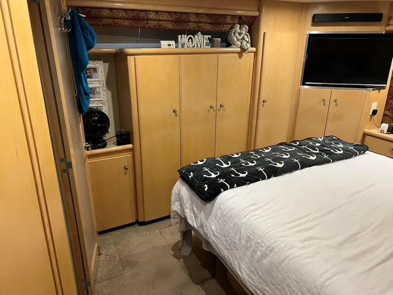 Slide: The Image of Interior of 1998 Carver 455 Aft Cabin Motoryacht bedroom with bed, cabinets, and TV. - 24