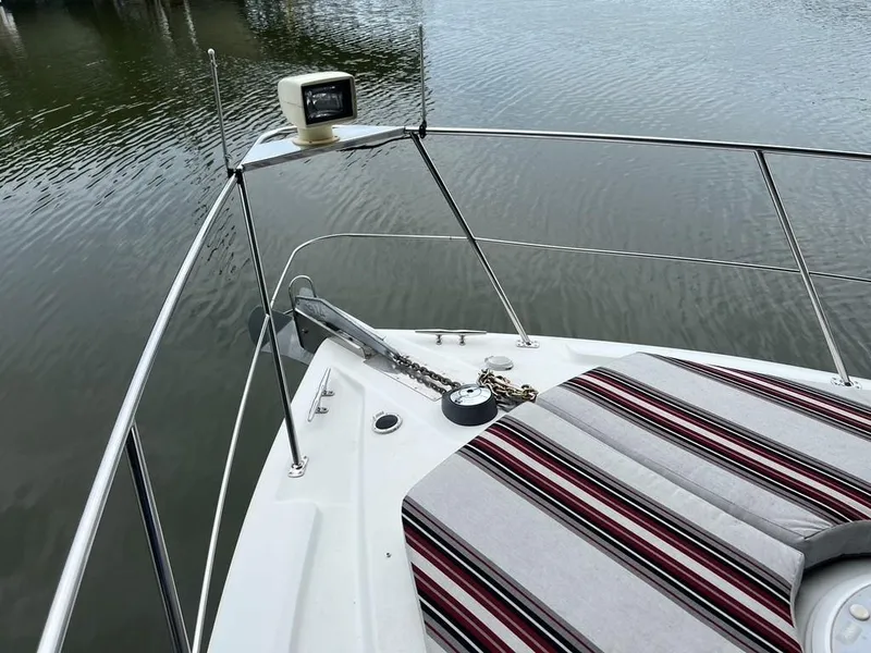 Slide: The Image of 1998 Carver 455 Aft Cabin Motoryacht bow with striped cushions and anchor chain. - 29