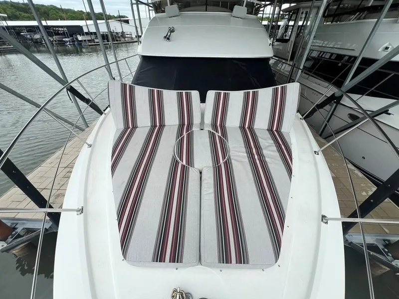 Slide: The Image of 1998 Carver 455 Aft Cabin Motoryacht with striped deck cushions, docked in a marina. - 31