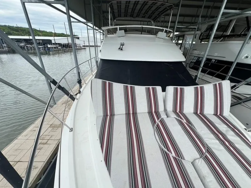 Slide: The Image of 1998 Carver 455 Aft Cabin Motoryacht with striped deck seating, docked in a marina. - 32