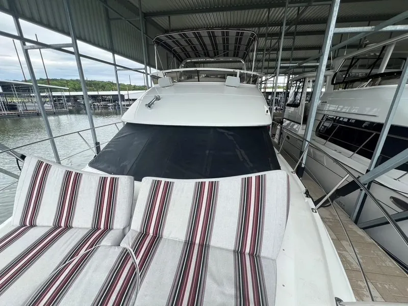 Slide: The Image of 1998 Carver 455 Aft Cabin Motoryacht docked with striped deck cushions. - 33