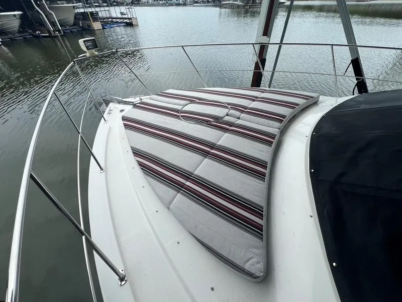 Slide: The Image of 1998 Carver 455 Aft Cabin Motoryacht with striped deck cushions on a calm marina. - 34