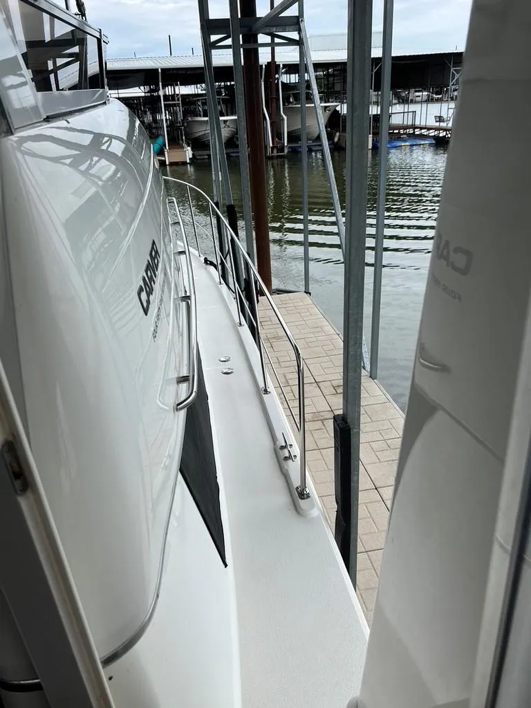 Slide: The Image of 1998 Carver 455 Aft Cabin Motoryacht docked, side view with railing and water background. - 39