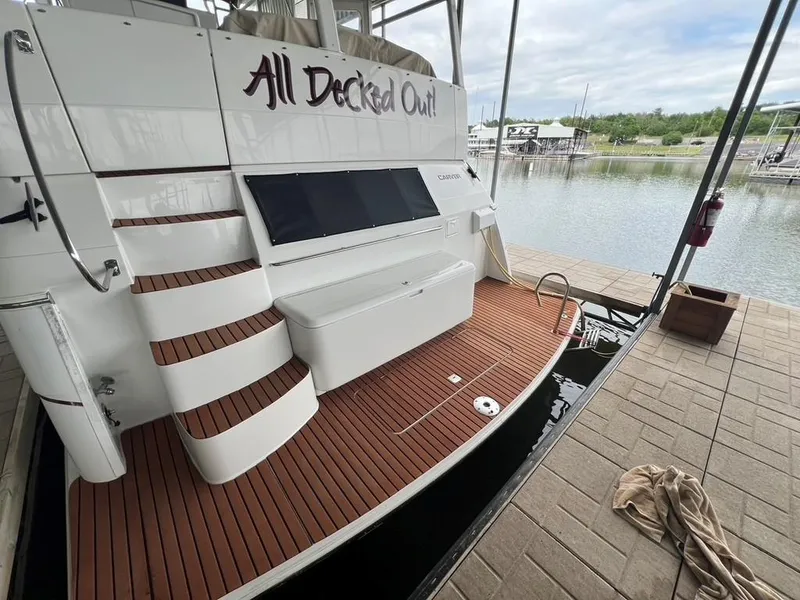 Slide: The Image of 1998 Carver 455 Aft Cabin Motoryacht docked, featuring teak deck and elegant staircase. - 4