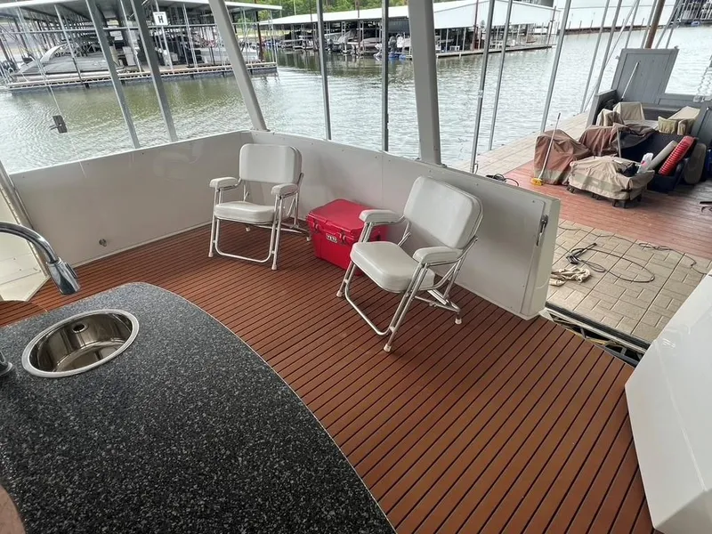 Slide: The Image of 1998 Carver 455 Aft Cabin Motoryacht deck with chairs and sink, docked at marina. - 41