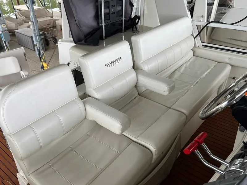 Slide: The Image of White leather seating on 1998 Carver 455 Aft Cabin Motoryacht, featuring helm and controls. - 46