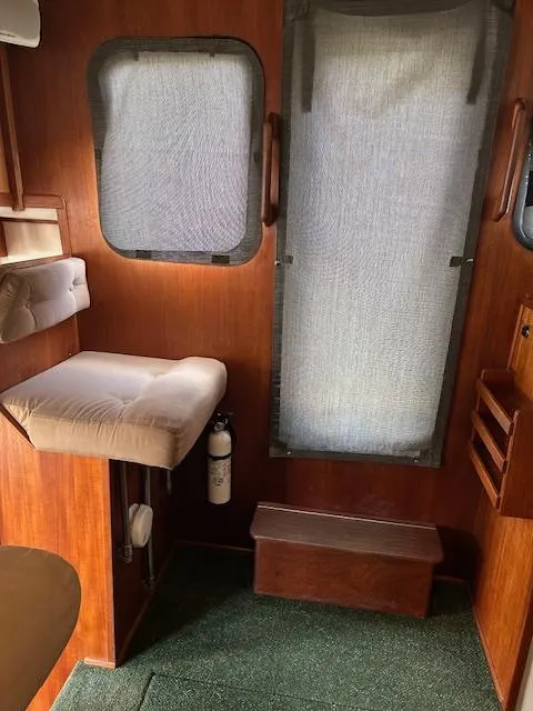 Slide: The Image of Interior of a 2001 Nordic Tug 32, featuring wood paneling and cushioned seating. - 10