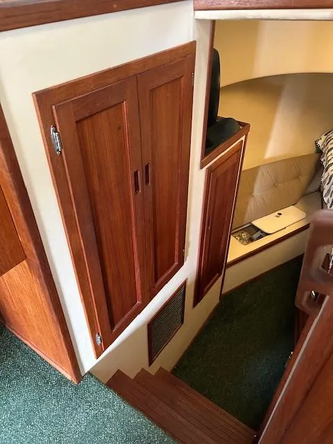 Slide: The Image of Interior of a 2001 Nordic Tug 32, featuring wooden cabinetry and cozy seating area. - 11