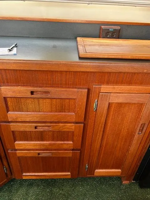 Slide: The Image of Wooden cabinetry inside a 2001 Nordic Tug 32, featuring drawers and a countertop. - 21