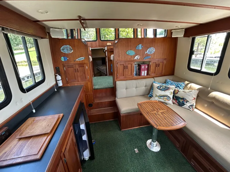 Slide: The Image of Interior of 2001 Nordic Tug 32 with cozy seating, wooden table, and decorative pillows. - 27