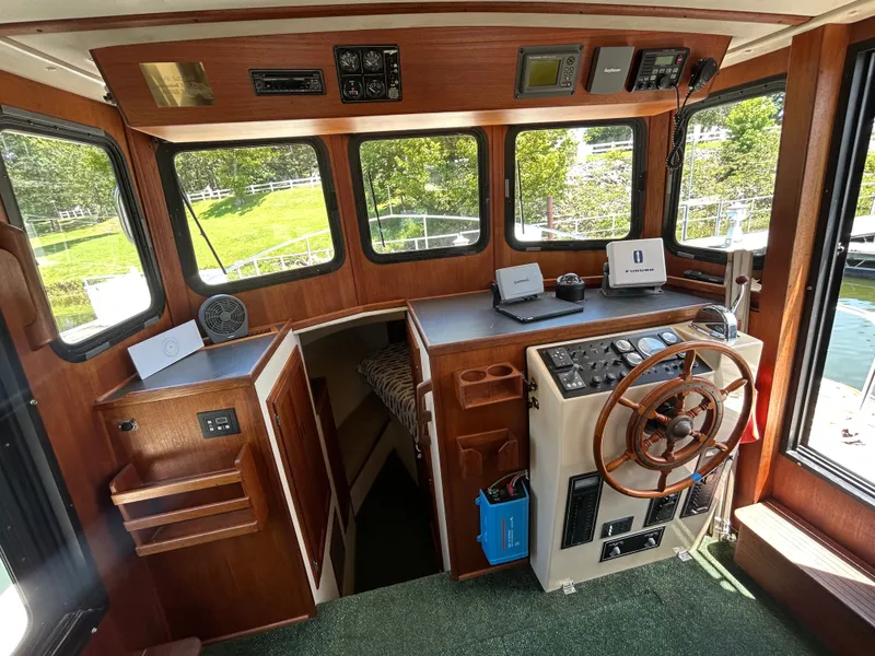 Slide: The Image of Cabin interior of a 2001 Nordic Tug 32 with wooden helm and navigation equipment. - 30