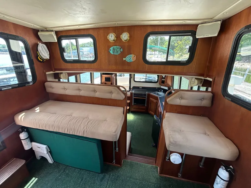 Slide: The Image of Interior of 2001 Nordic Tug 32 with cushioned seating and wooden accents. - 32
