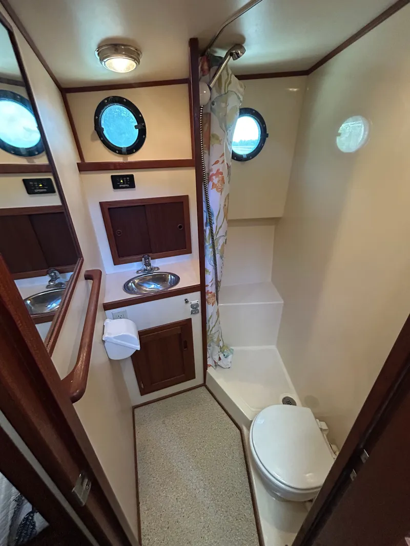 Slide: The Image of Bathroom interior of a 2001 Nordic Tug 32, featuring sink, toilet, and shower. - 35