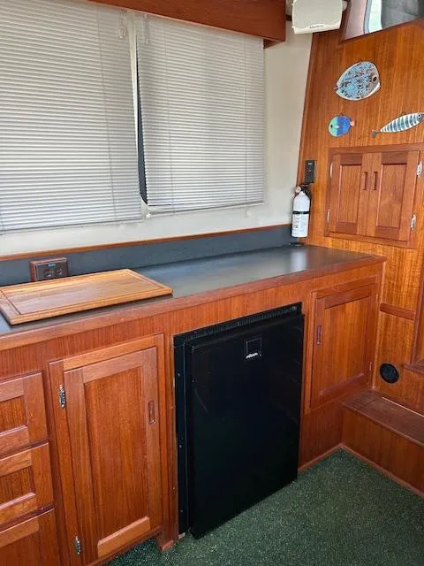 Slide: The Image of Interior of 2001 Nordic Tug 32 with wooden cabinetry and compact refrigerator. - 7