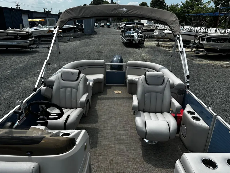 Slide: The Image of 2019 Bennington SSRX Pontoon 22 with plush seating, parked in a boatyard. - 11
