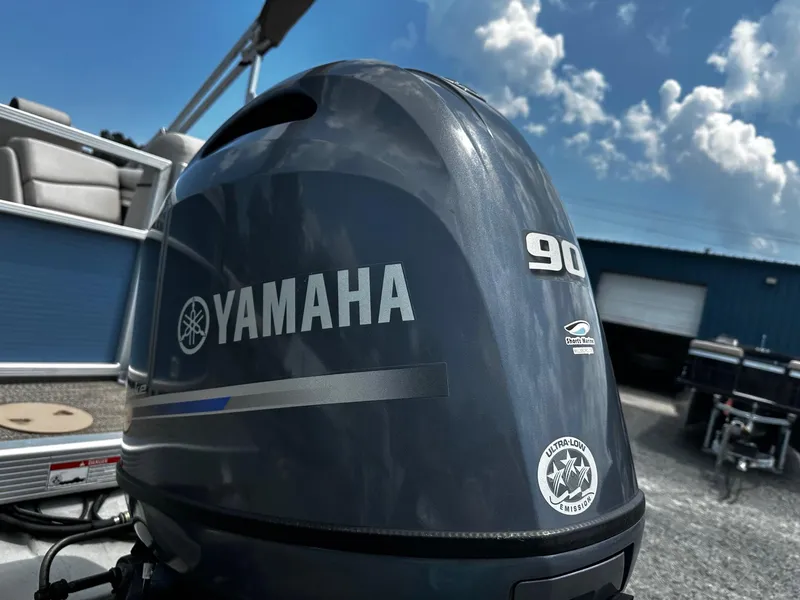 Slide: The Image of 2019 Bennington SSRX Pontoon 22 with Yamaha 90 outboard motor under blue sky. - 23
