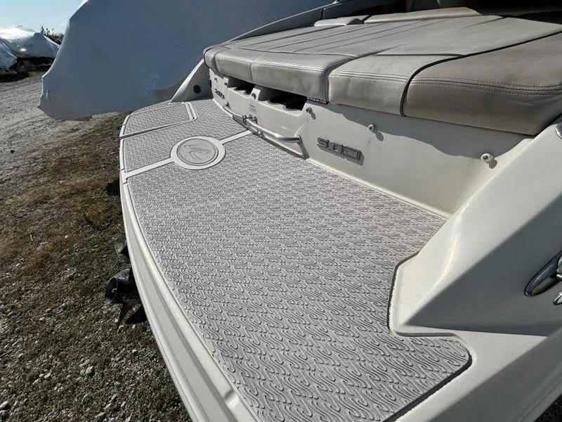 Slide: The Image of 2010 Sea Ray 210 Select boat with cushioned seating and textured deck. - 12