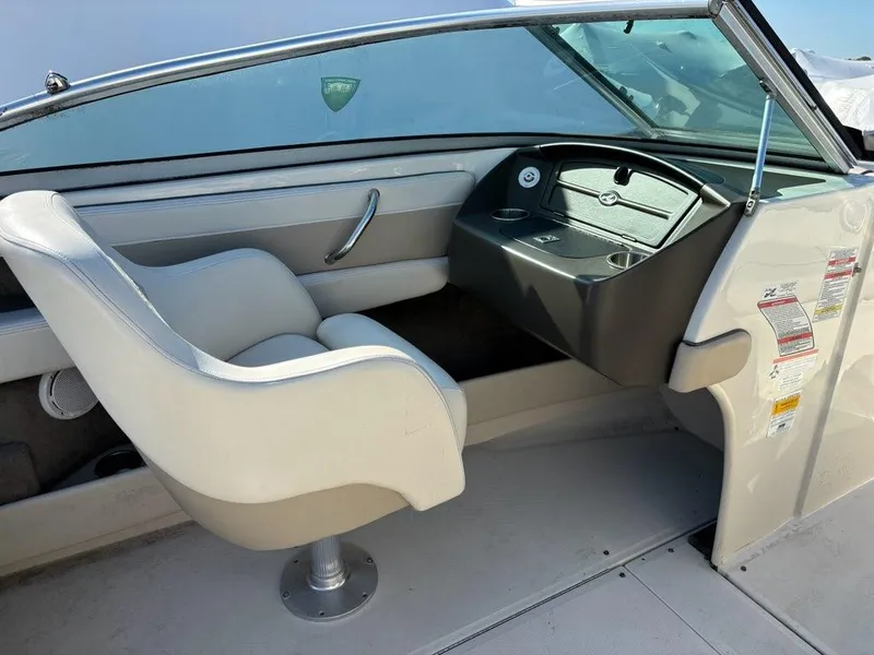 Slide: The Image of 2010 Sea Ray 210 Select boat interior with white captain's chair and dashboard. - 4