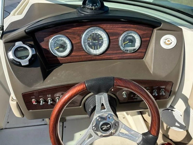Slide: The Image of Dashboard of a 2010 Sea Ray 210 Select boat with wood accents and gauges. - 6