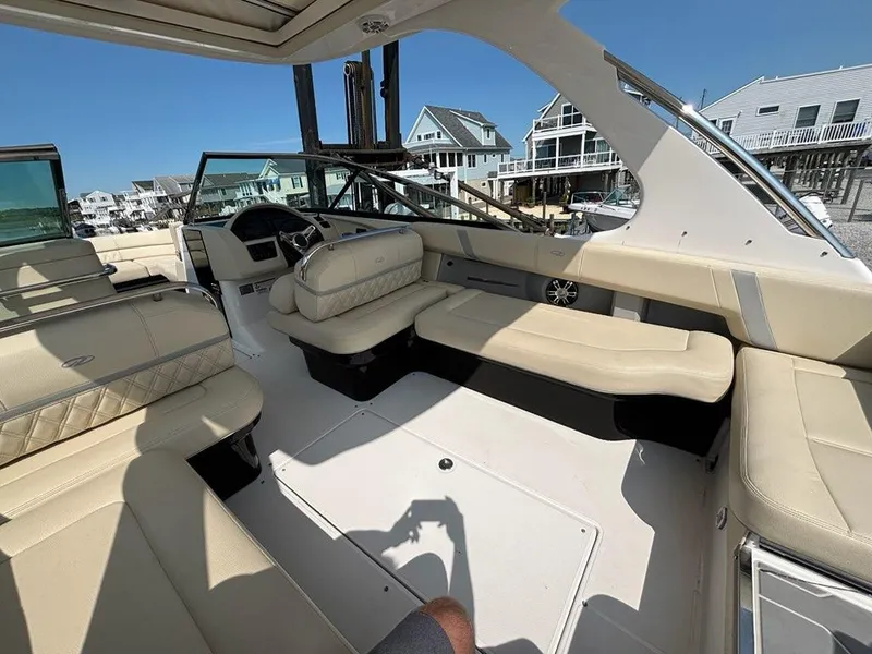 Slide: The Image of 2020 Regal 2800 Bowrider interior with beige seating, docked near waterfront homes. - 14