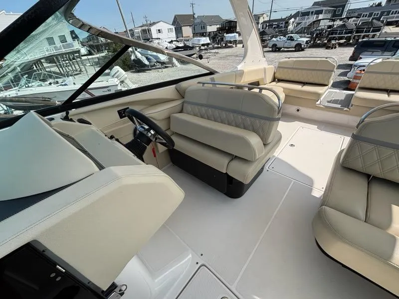 Slide: The Image of 2020 Regal 2800 Bowrider interior with beige seating and steering wheel, docked in a marina. - 15