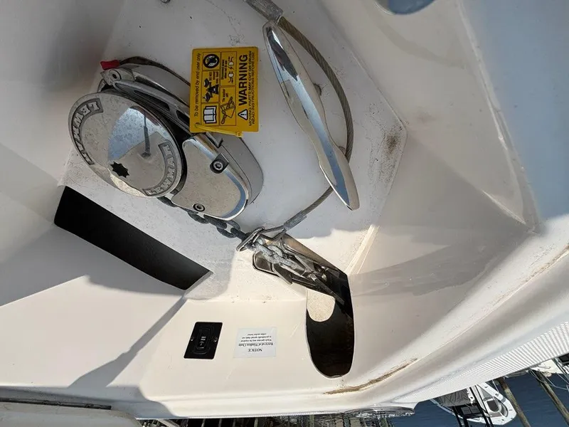 Slide: The Image of 2020 Regal 2800 Bowrider anchor compartment with warning label and winch system. - 5