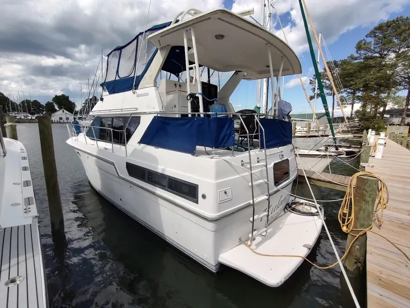 The Image of 1992 Carver 36 Aft Cabin yacht docked at marina, featuring blue canopy and spacious deck. - 0