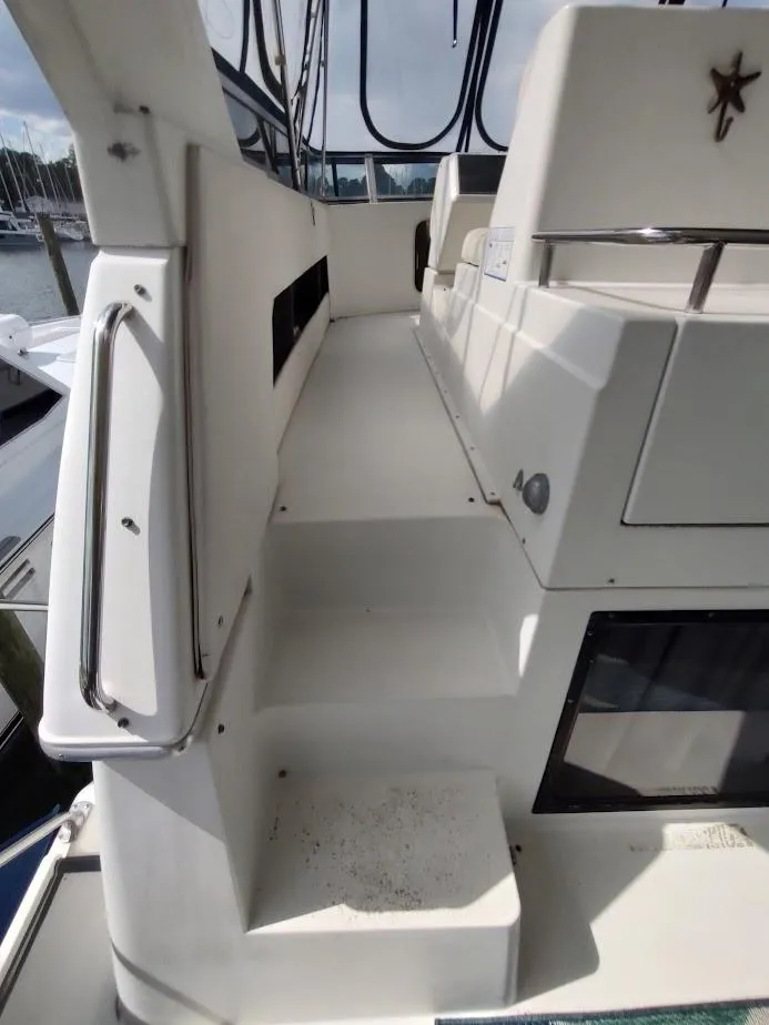 Slide: The Image of 1992 Carver 36 Aft Cabin yacht deck with seating and railing, docked at marina. - 16