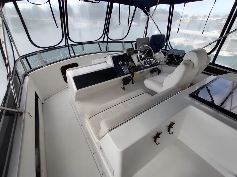 Slide: The Image of 1992 Carver 36 Aft Cabin helm with seating, steering wheel, and navigation equipment. - 17