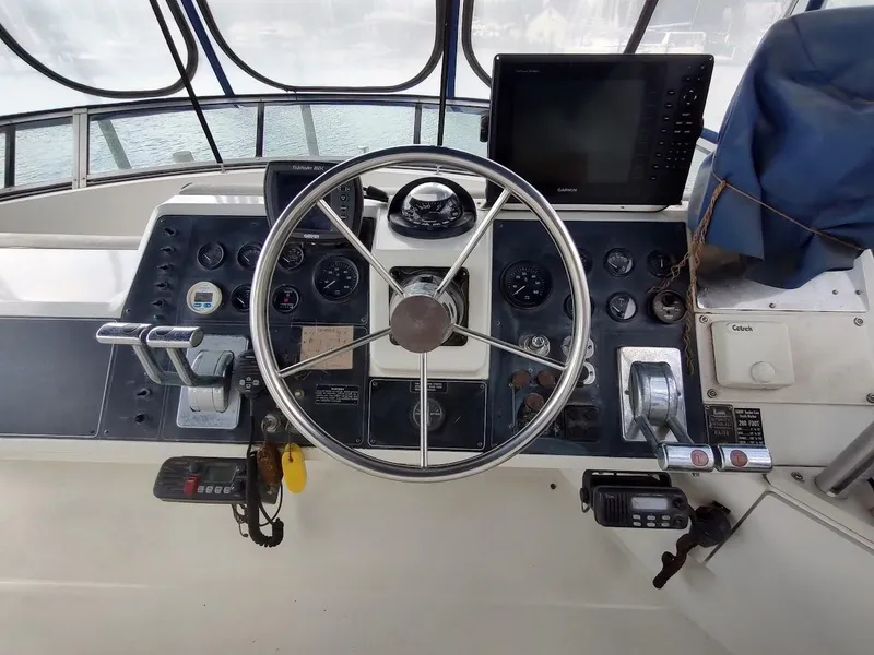 Slide: The Image of 1992 Carver 36 Aft Cabin helm with steering wheel, gauges, and navigation equipment. - 19