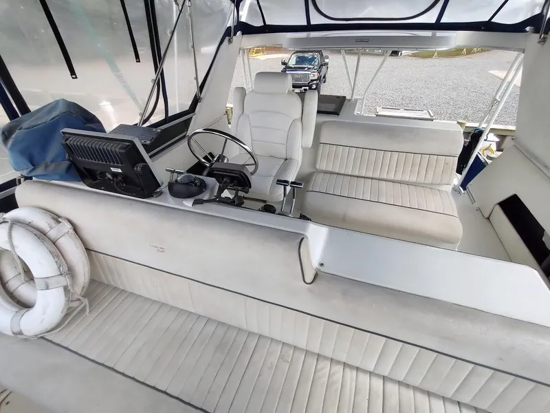 Slide: The Image of 1992 Carver 36 Aft Cabin interior with white seating and steering console. - 30