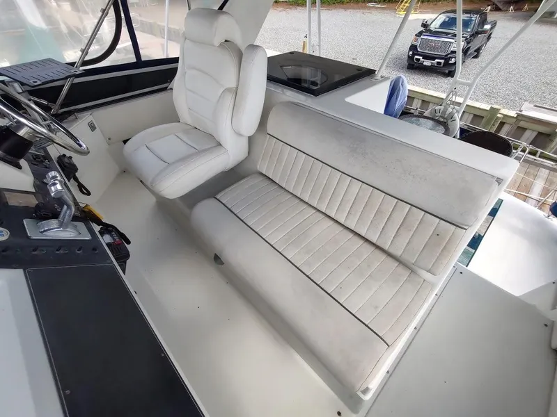 Slide: The Image of 1992 Carver 36 Aft Cabin helm with white seating and control panel. - 31