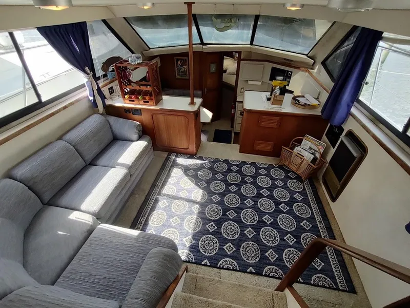 Slide: The Image of Interior of 1992 Carver 36 Aft Cabin with cozy seating, blue rug, and kitchenette. - 34