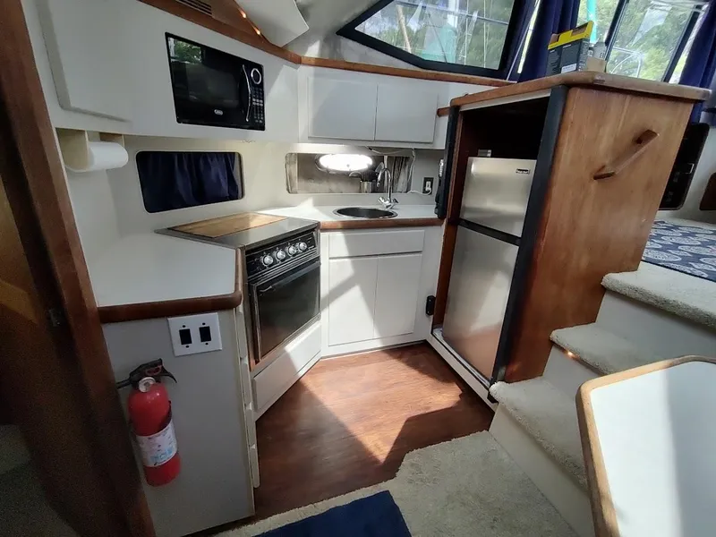 Slide: The Image of 1992 Carver 36 Aft Cabin kitchen with stove, microwave, and refrigerator. - 40
